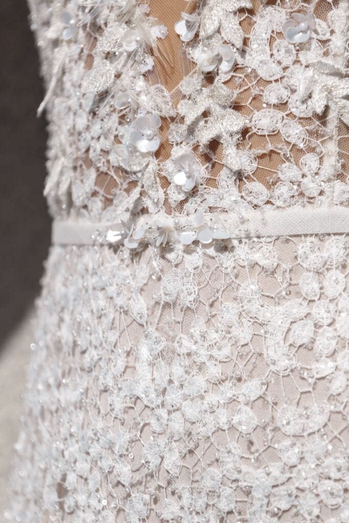 White lace dress with floral embroidery and sequins.