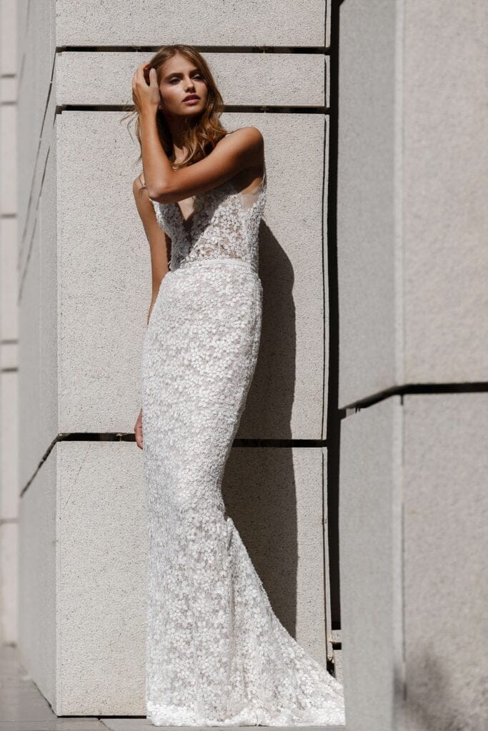 Woman in white lace gown in sunlight.