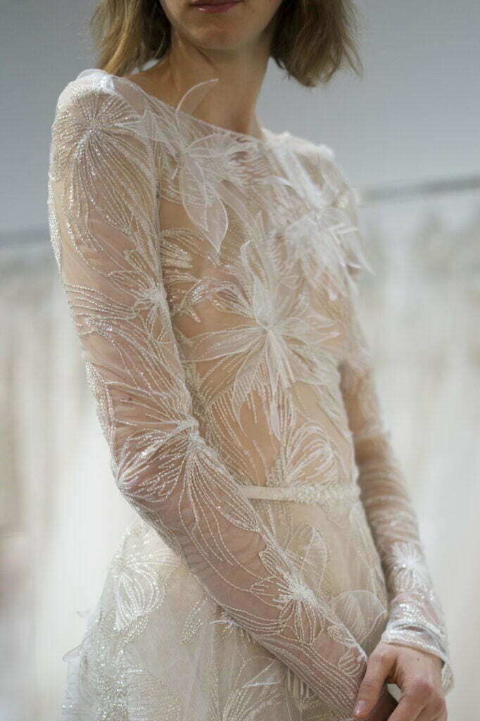 Person in sheer, embroidered white gown.
