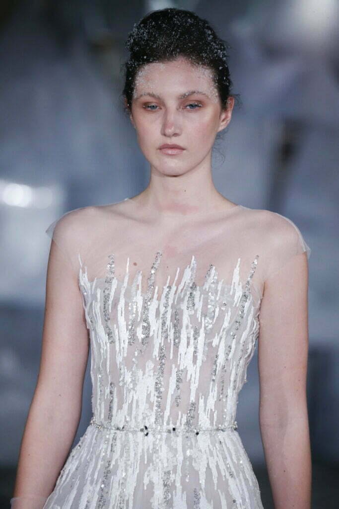 Model in silver gown with glitter makeup.