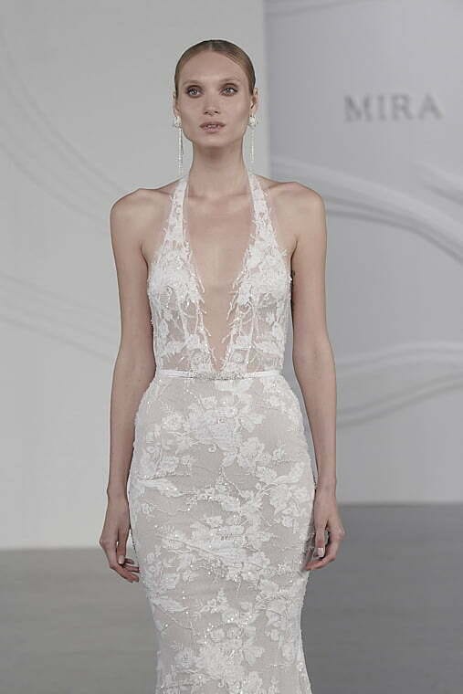 Model in fitted white lace wedding dress.