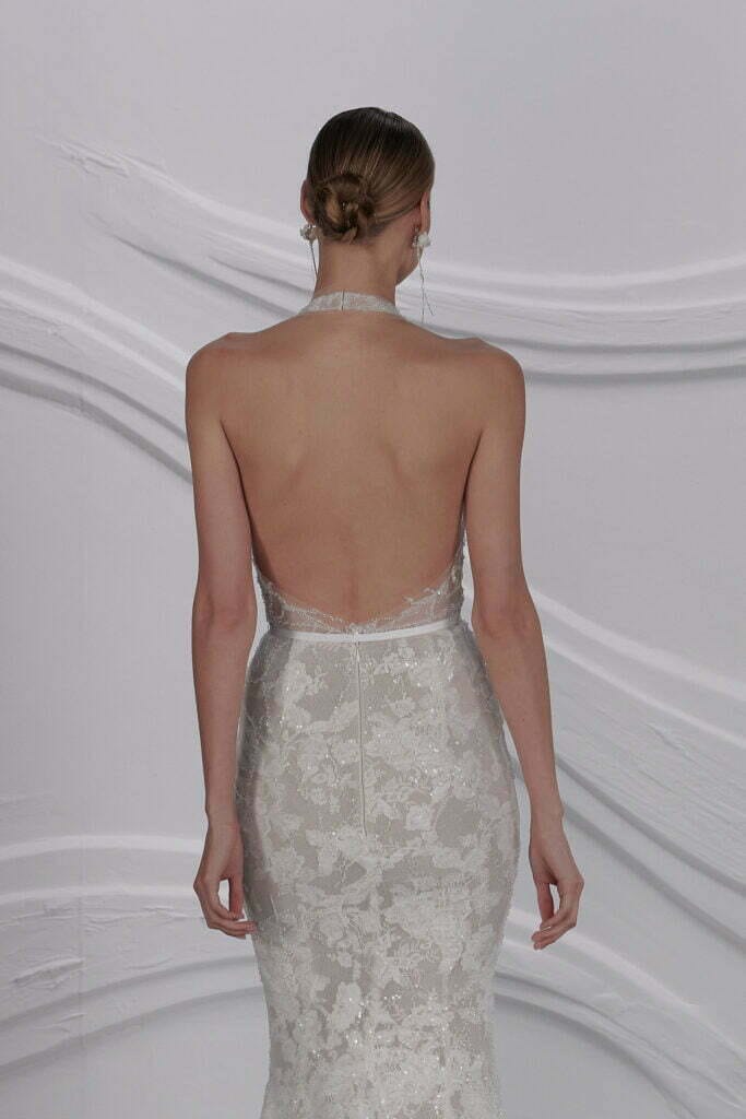 Woman in backless lace halter wedding gown.