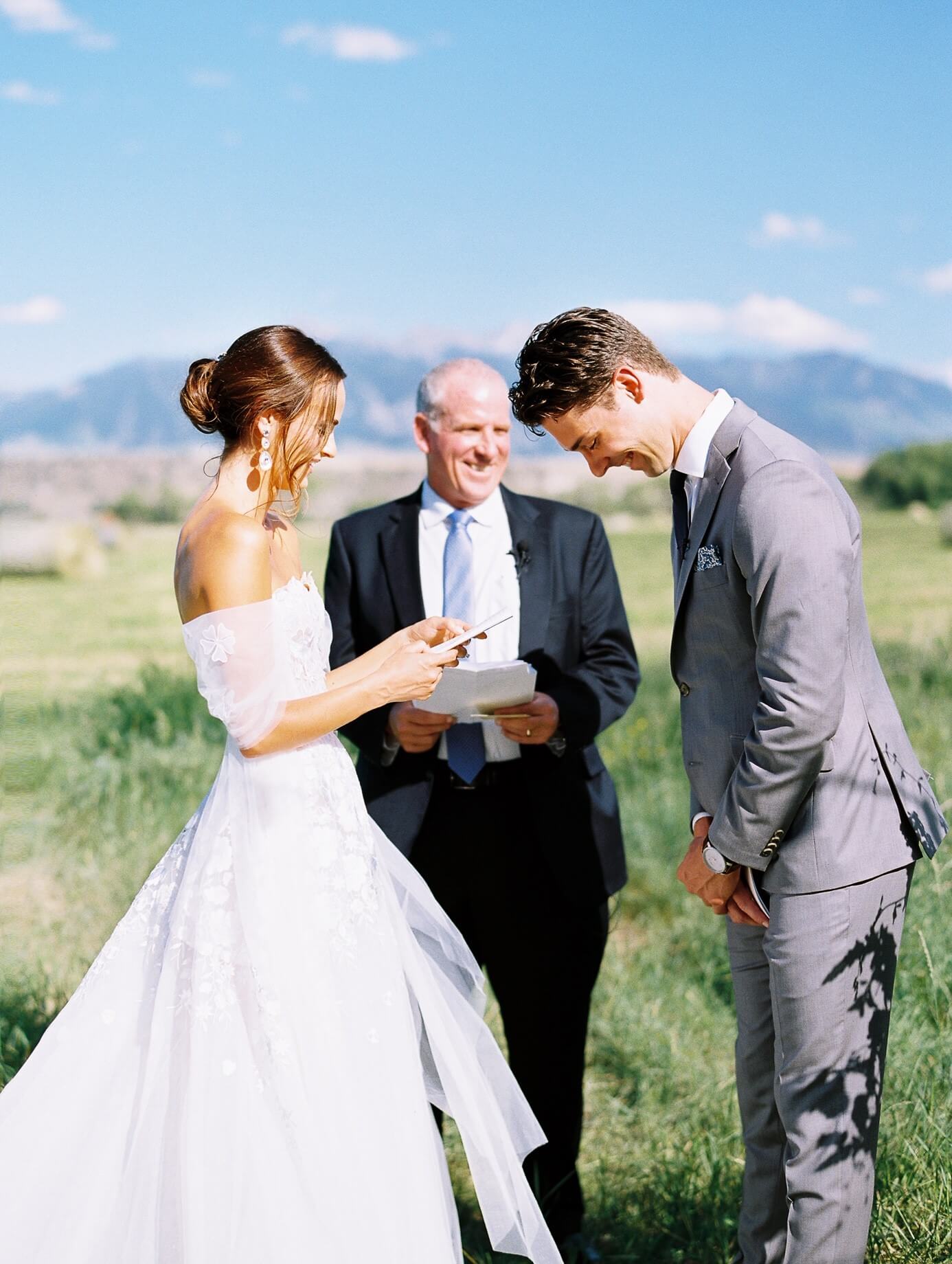 Bride and groom laughing during outdoor vows.