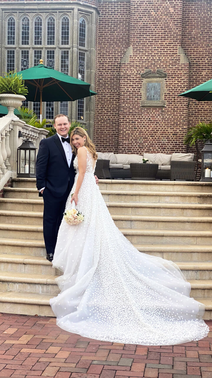 Bride and groom pose on outdoor steps.
