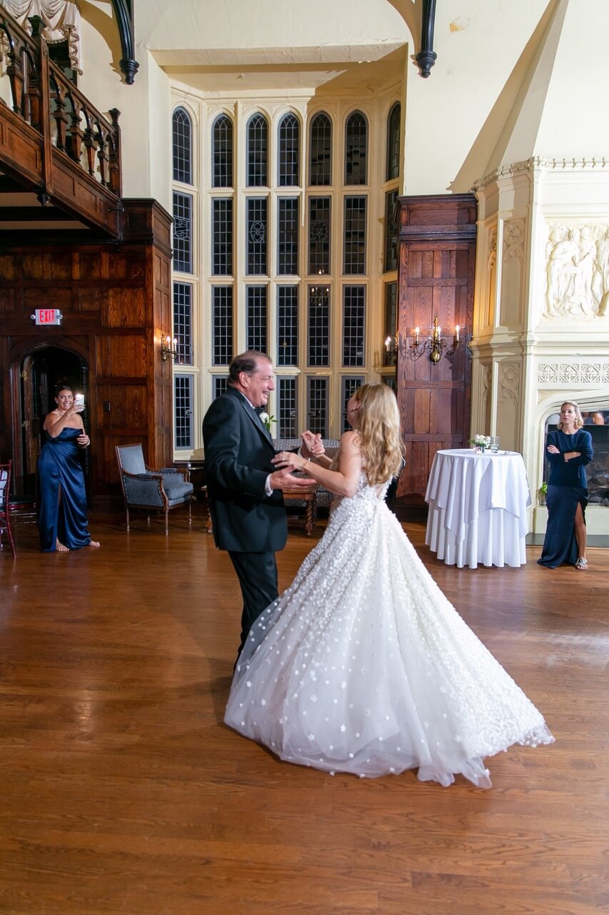 Bride and older man dancing at reception.