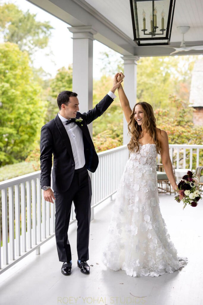 Bride and groom twirl, holding bouquet.