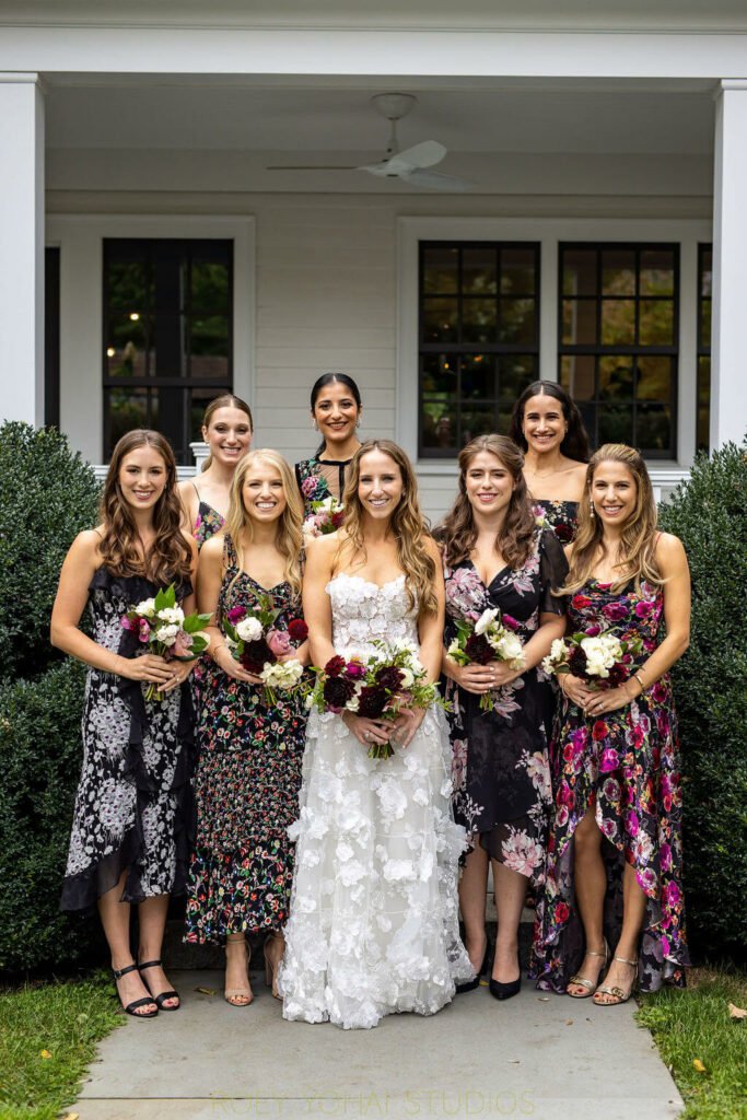 Bride and bridesmaids smiling with bouquets outside.