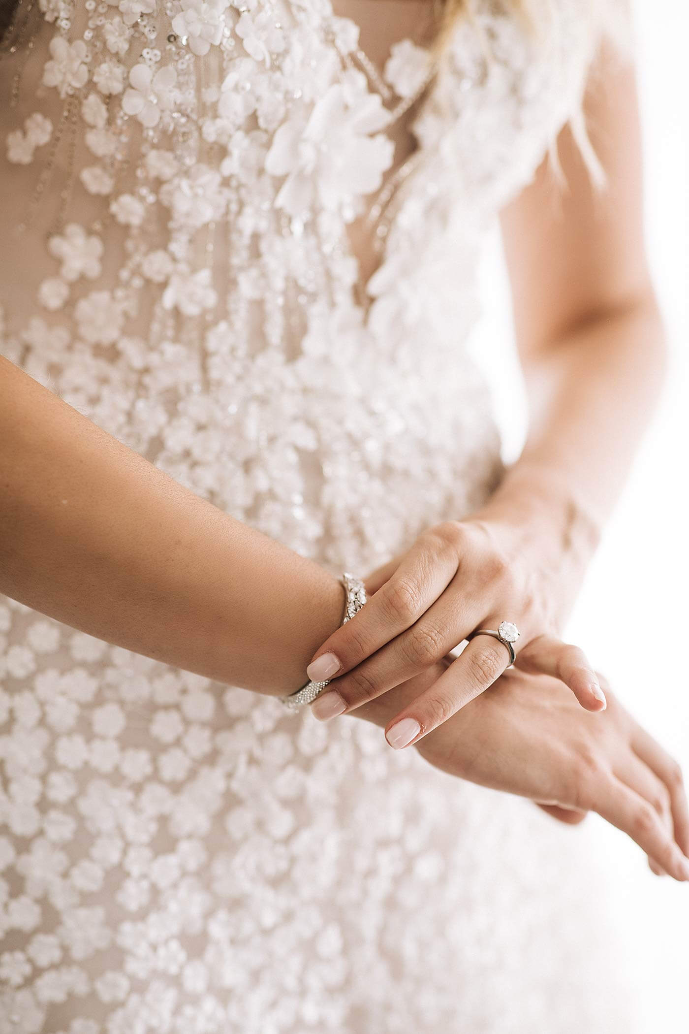 Bride’s hands with diamond ring and bracelet.