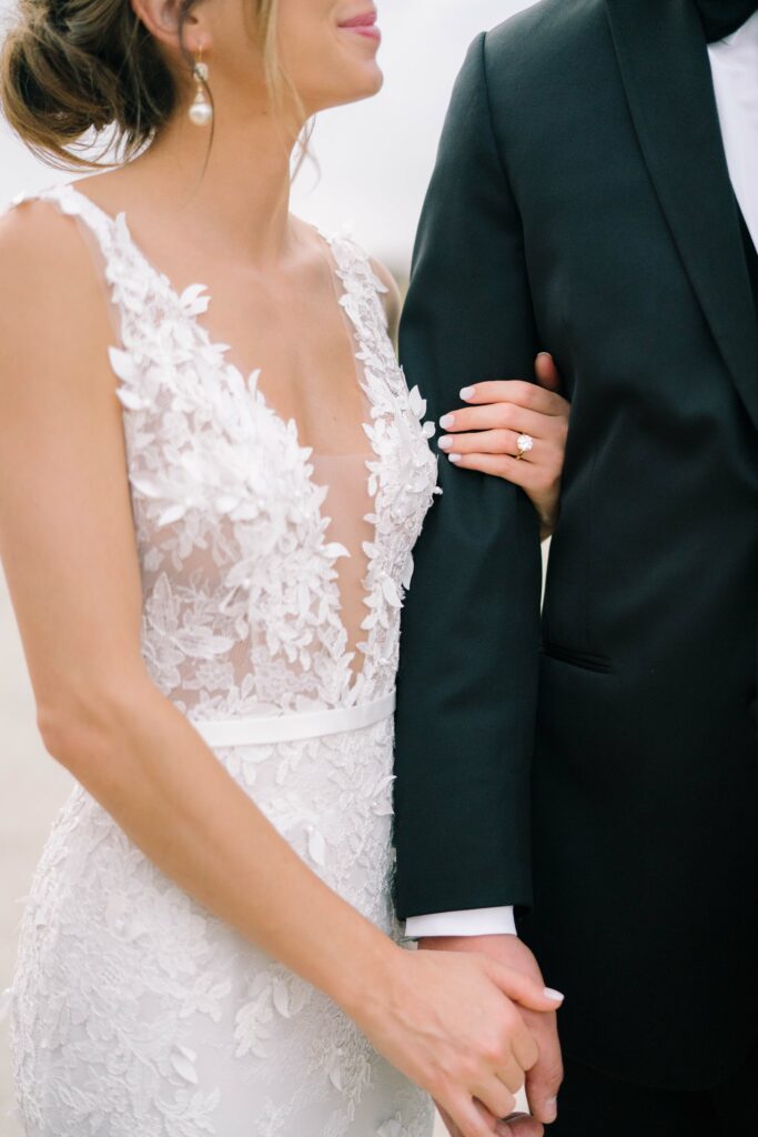 Bride and groom holding hands, faces cropped.