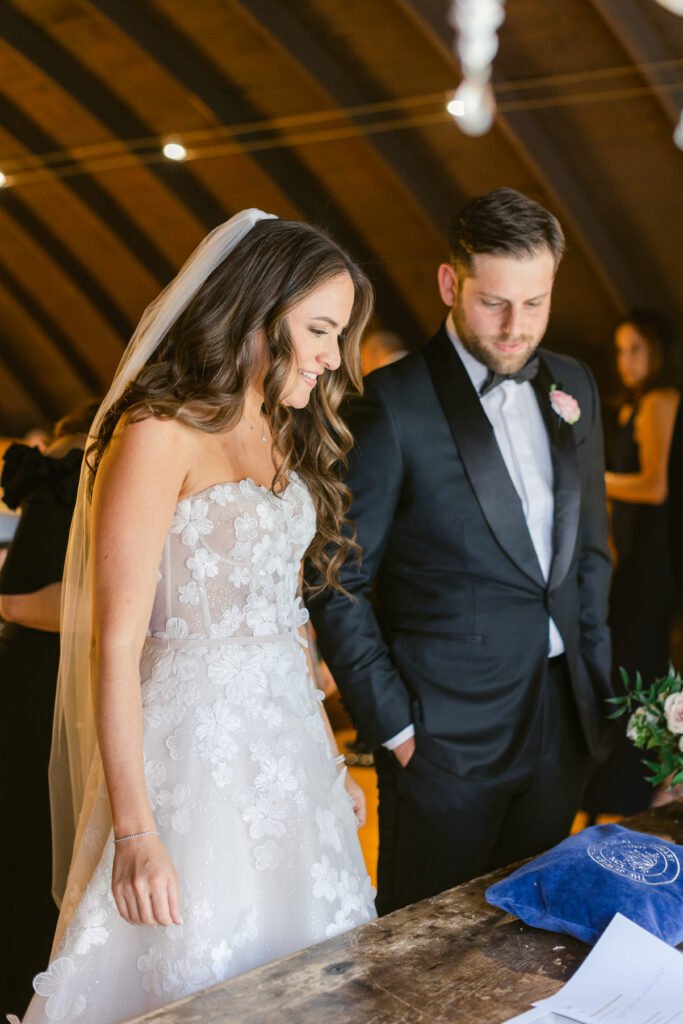 Bride and groom signing documents indoors.