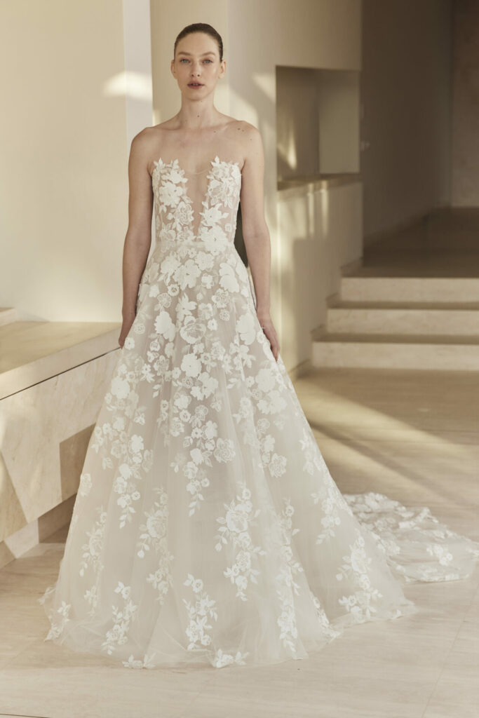 Woman in strapless lace wedding gown indoors.