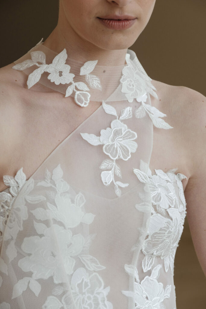 Close-up of sheer white floral lace dress.