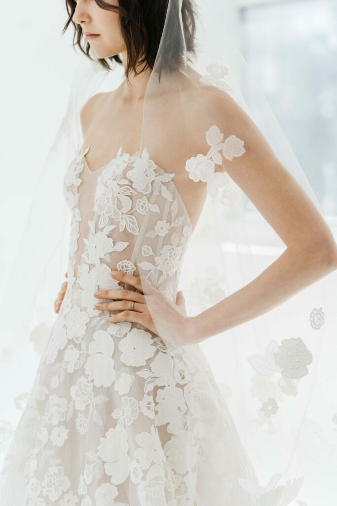 Woman in floral lace wedding dress and veil.