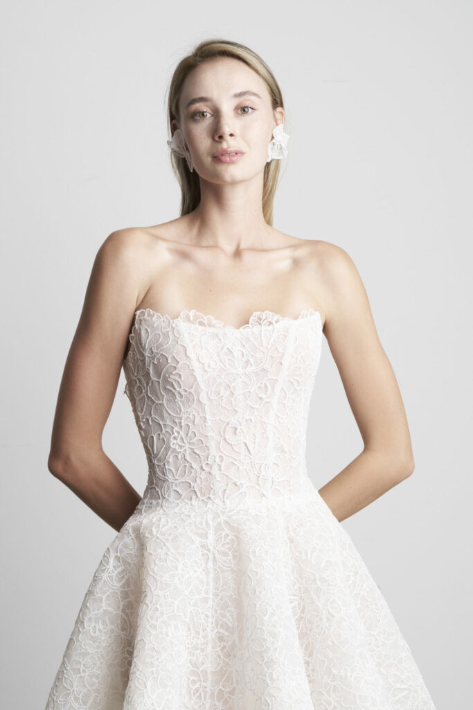 Woman in strapless lace wedding dress, earrings.