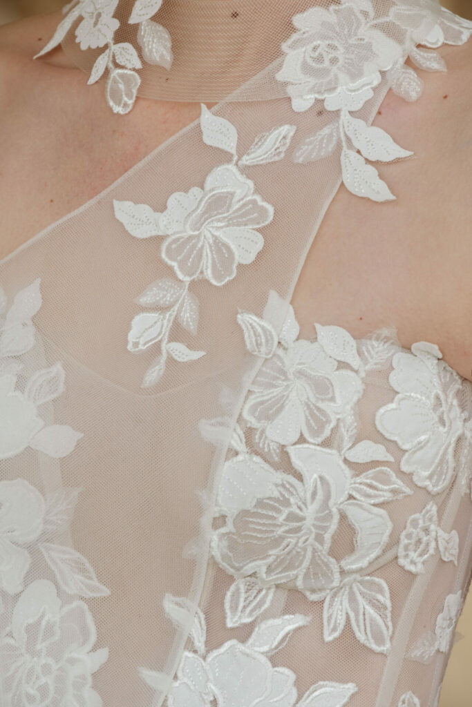 Sheer fabric with white floral lace embroidery.