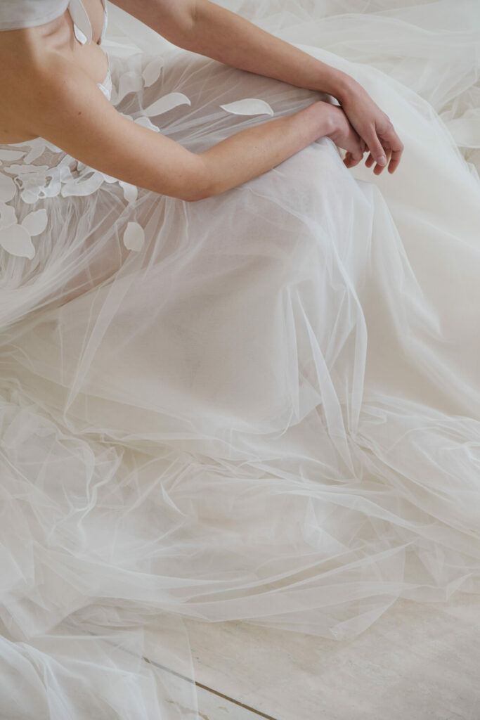 Person in floral wedding dress sitting on floor.
