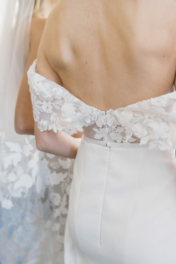 Brides in lace-trimmed off-shoulder wedding dresses.
