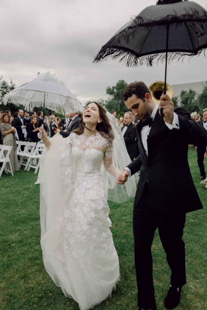 Bride and groom celebrate outdoors with guests.