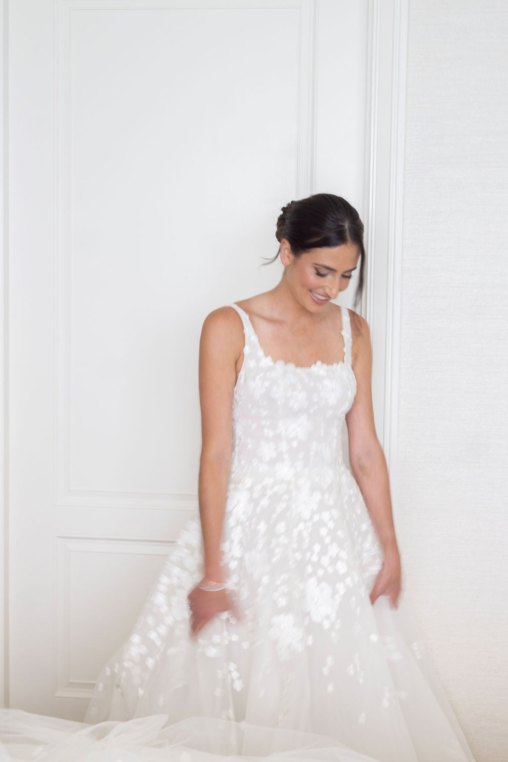 Smiling woman in floral wedding dress.