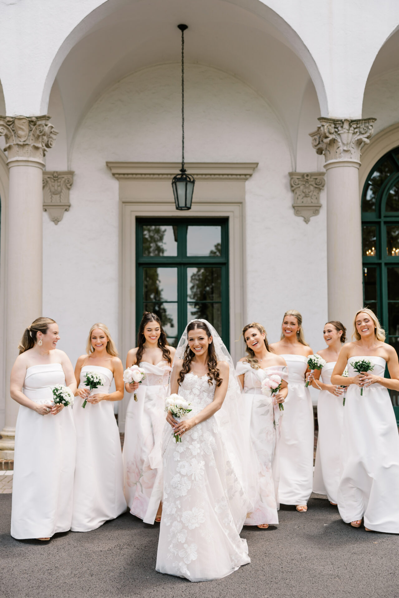 Bride and six bridesmaids pose with bouquets.