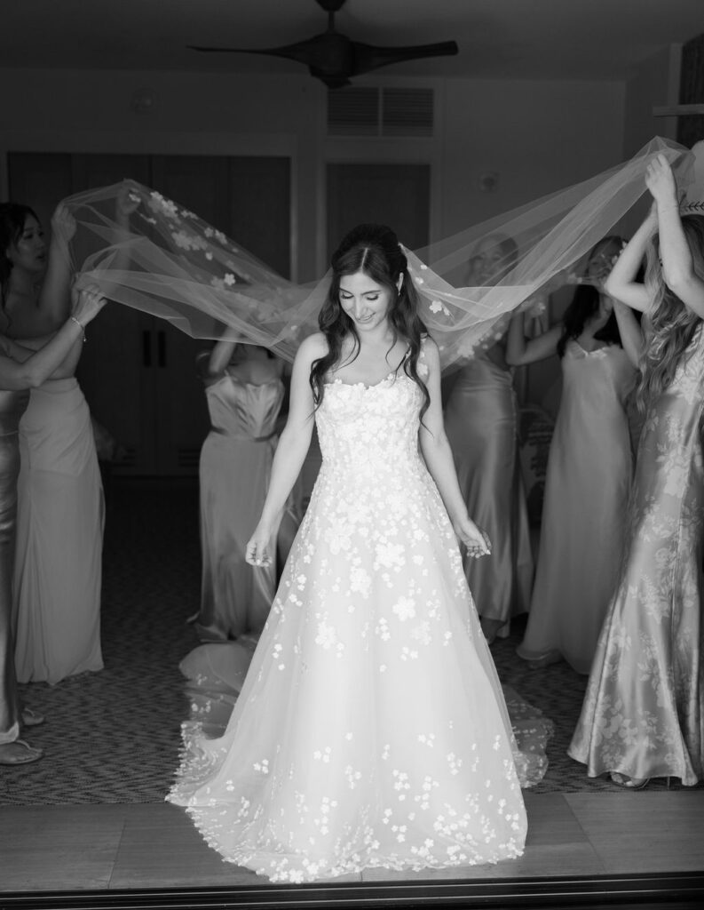 Bride Katya Ruiz in floral dress, veil held.