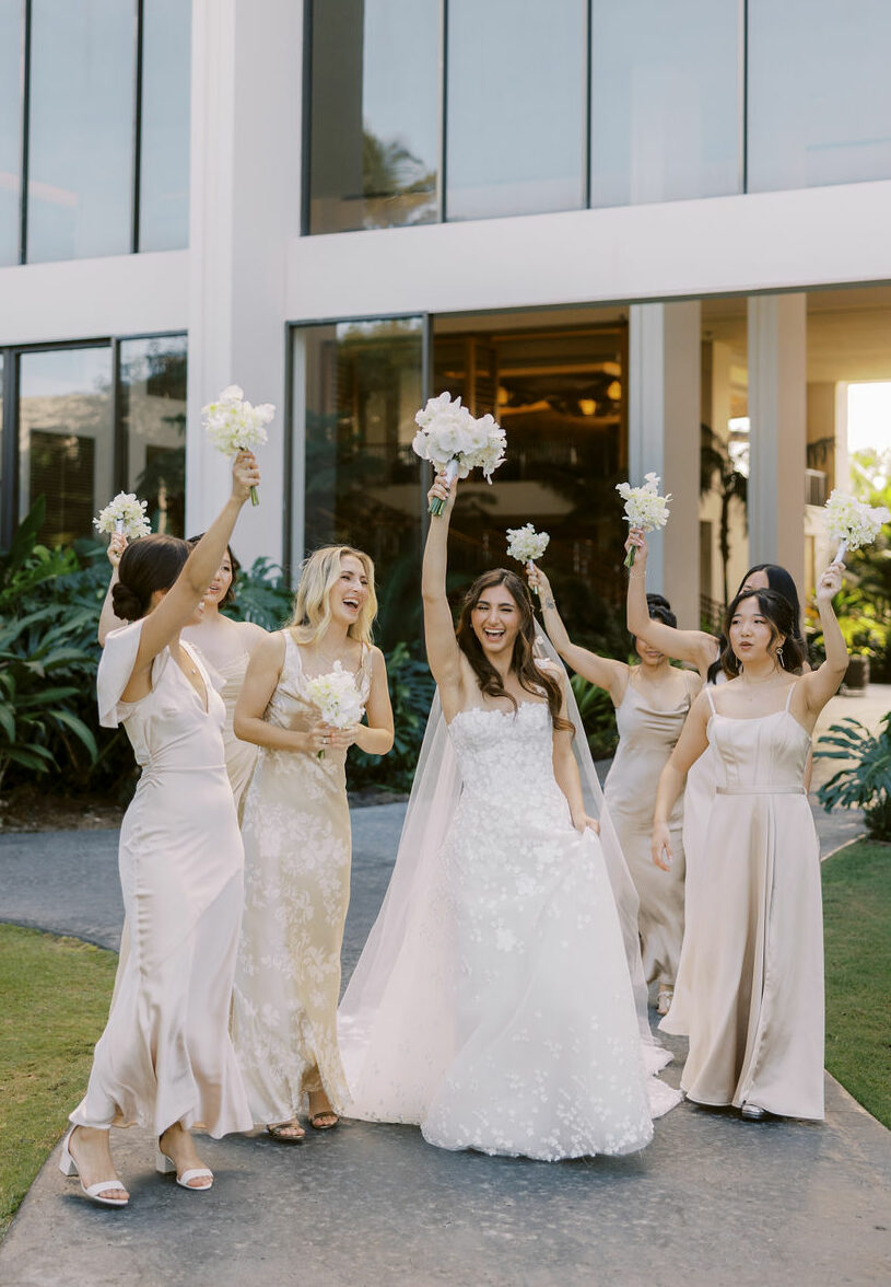 Katya Ruiz with bridesmaids in luxe gowns outdoors.