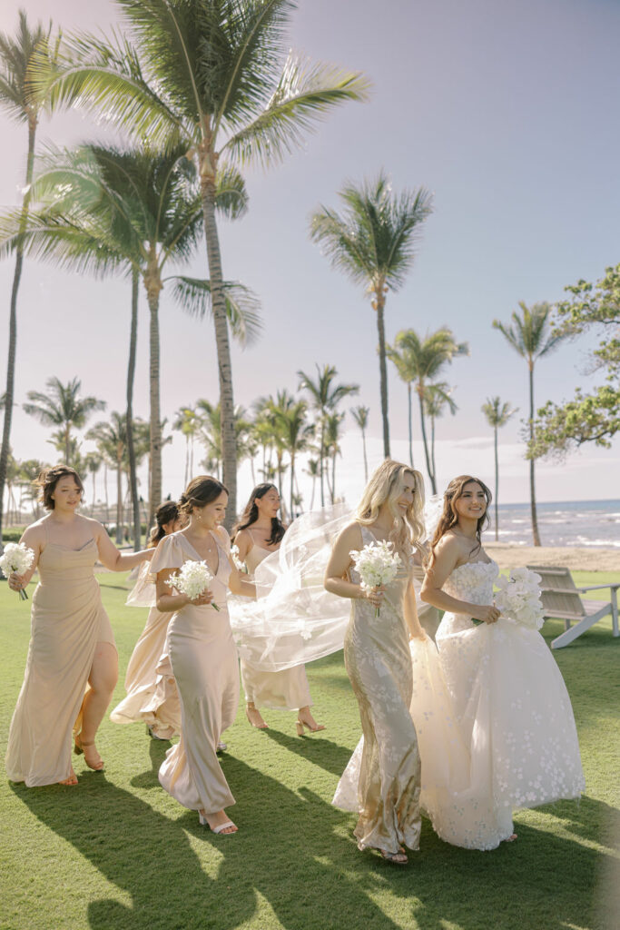 Katya Ruiz and bridesmaids walk by beach.