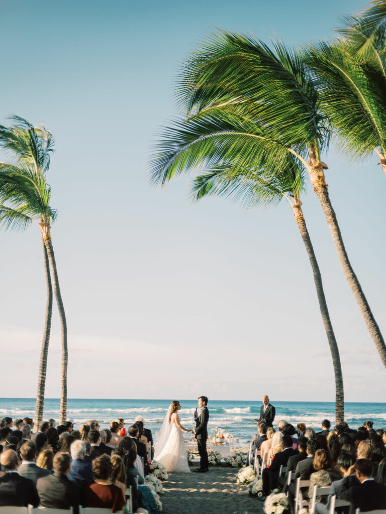 Bride Katya Ruiz weds on beach under palms.