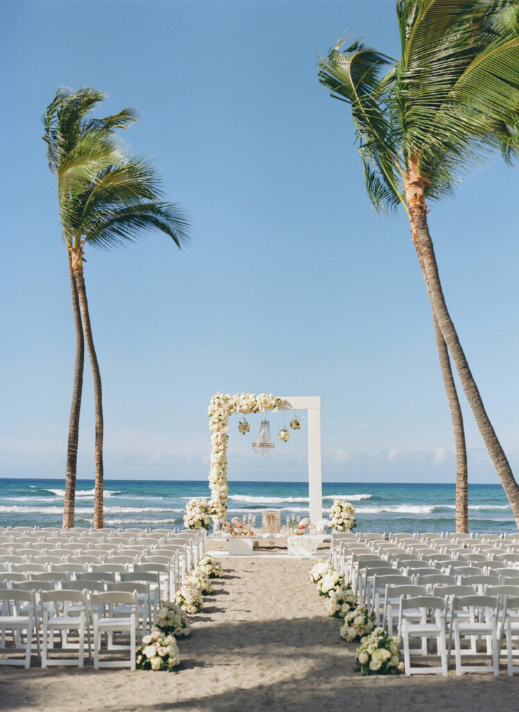 Bride Katya Ruiz in gown at beach altar.