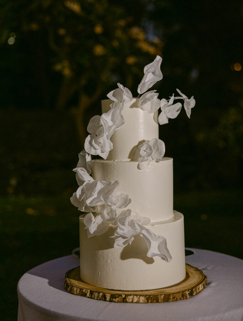 Elegant white wedding cake with cascading flowers.