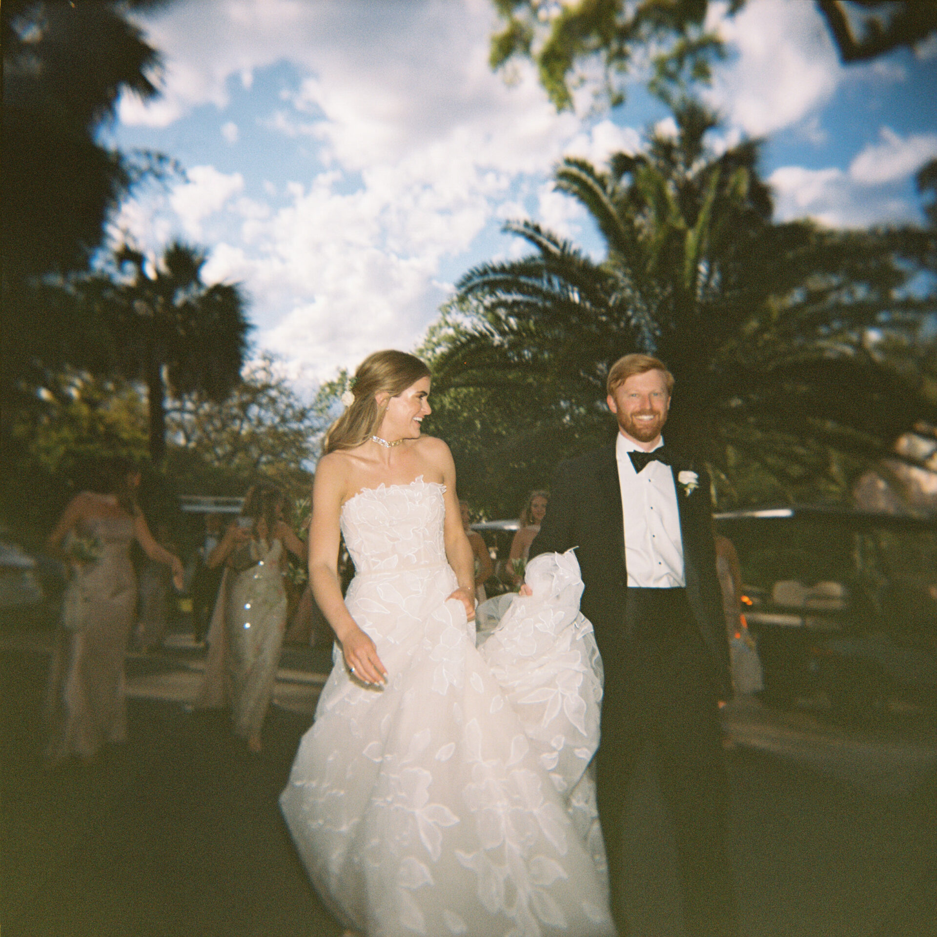 Smiling bride and groom walking outdoors.