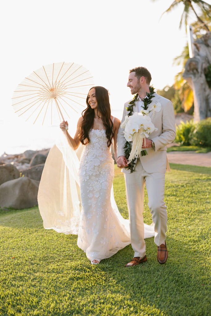 Bride and groom walk outdoors, smiling.