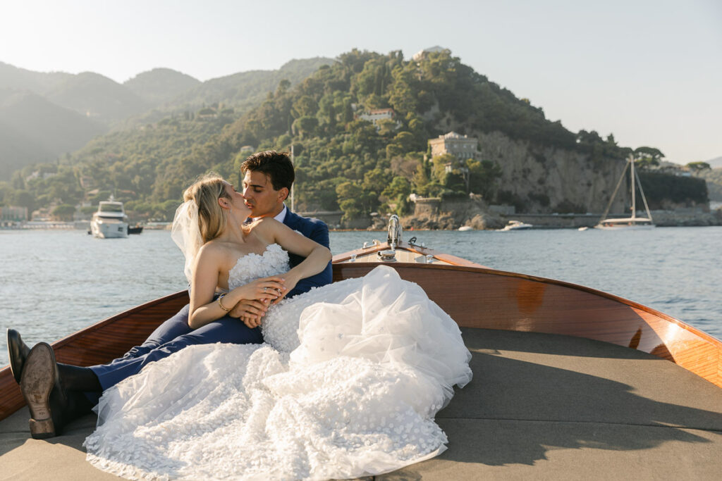 Bride and groom on boat, sunny day.