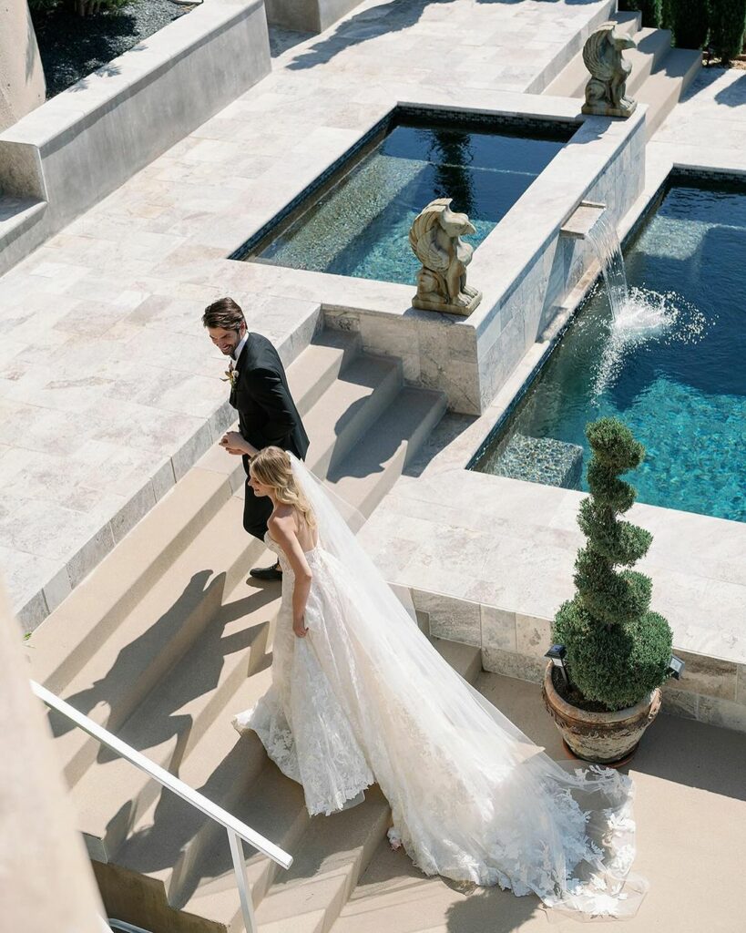 Bride and groom by poolside steps.