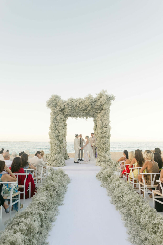 Bride Katya Ruiz weds under floral arch.
