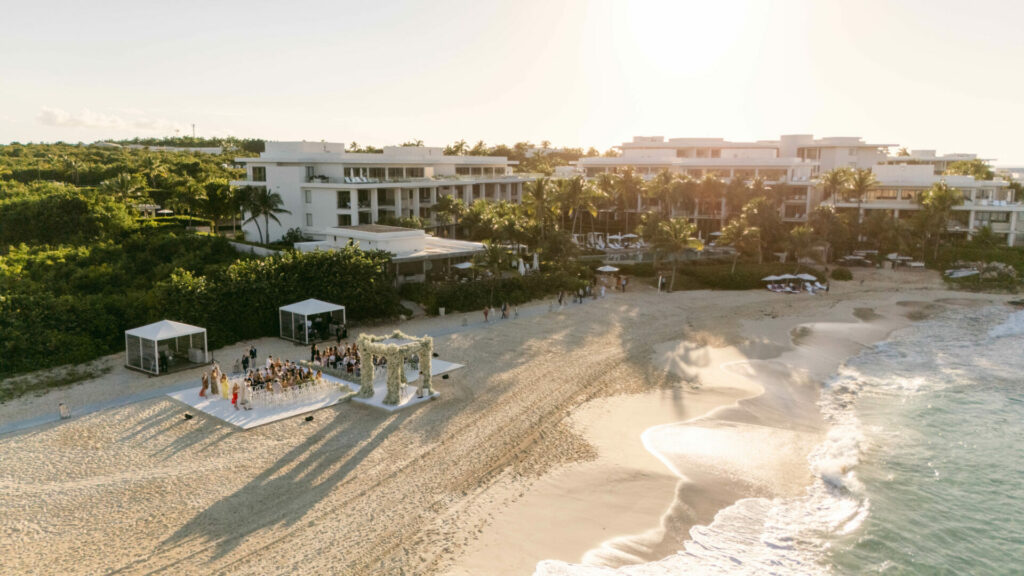 Beach wedding at sunset with floral arch.
