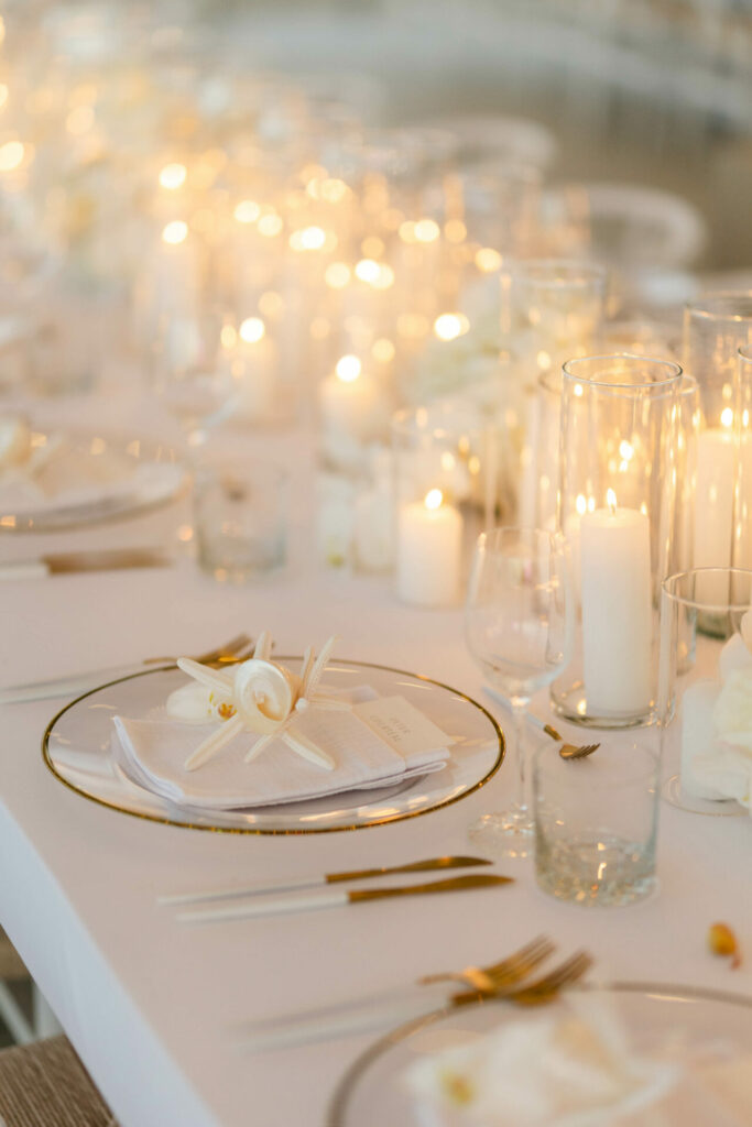 Elegant candlelit table with gold utensils.