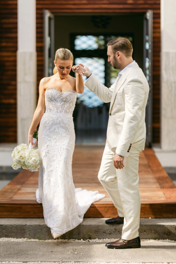 Man holds bride Katya Ruizs hand, luxurious gown.