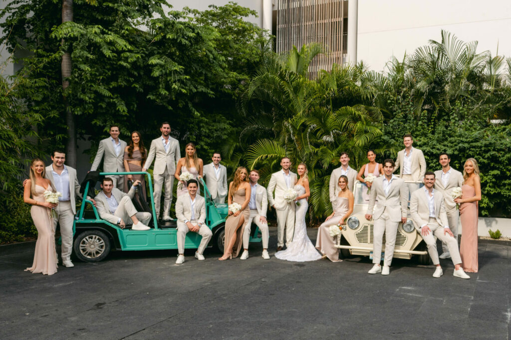 Wedding party outdoors with vintage cars.