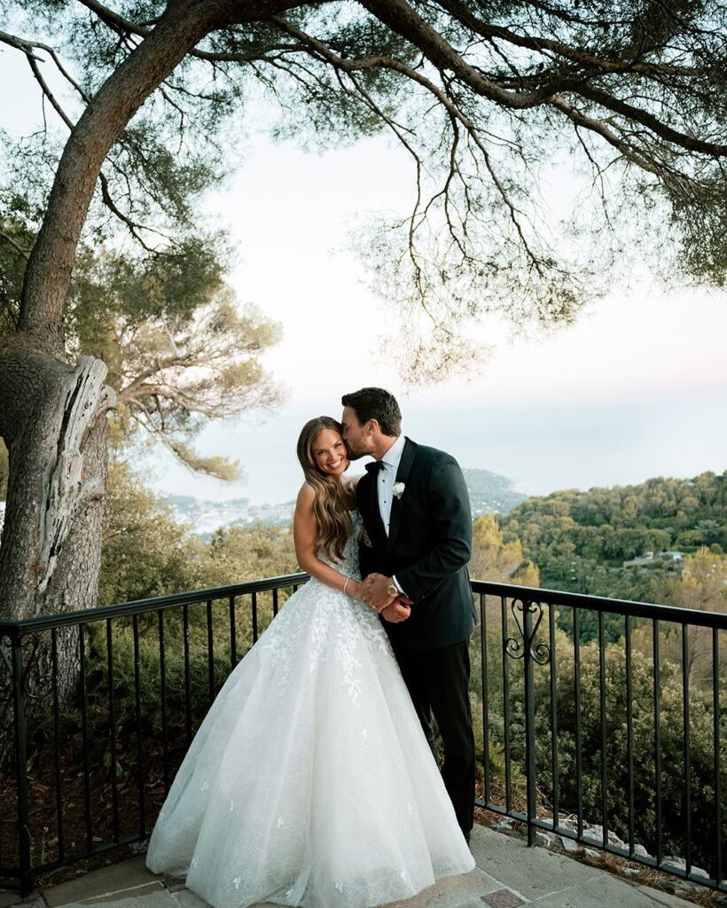 Bride and groom on terrace, scenic background.