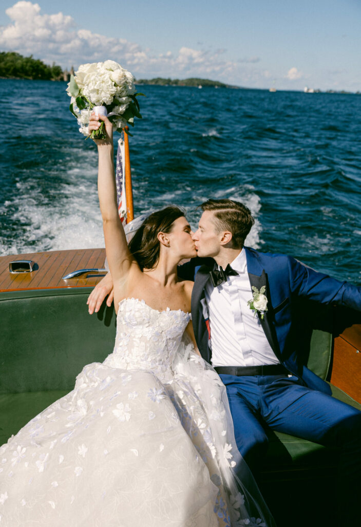 Bride and groom kiss on boat, celebrating.