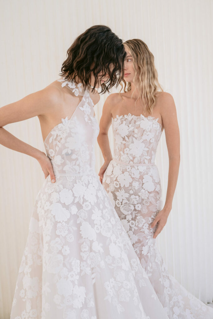 Two women in elegant white lace dresses.