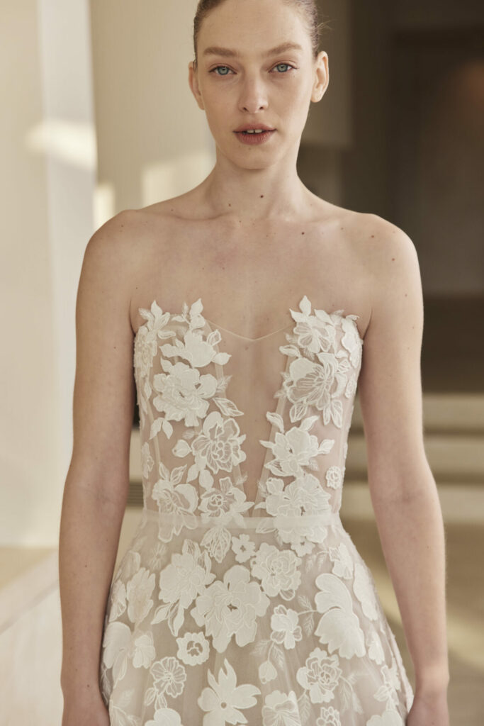 Woman in floral strapless wedding dress indoors.