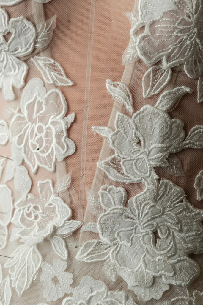 White floral lace embroidery on sheer fabric.