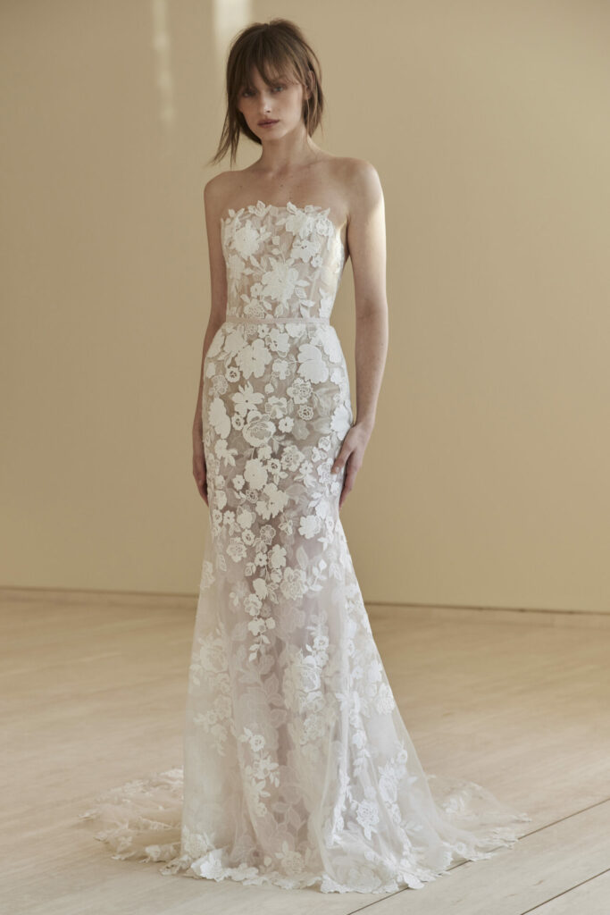 Woman in strapless lace wedding gown indoors.