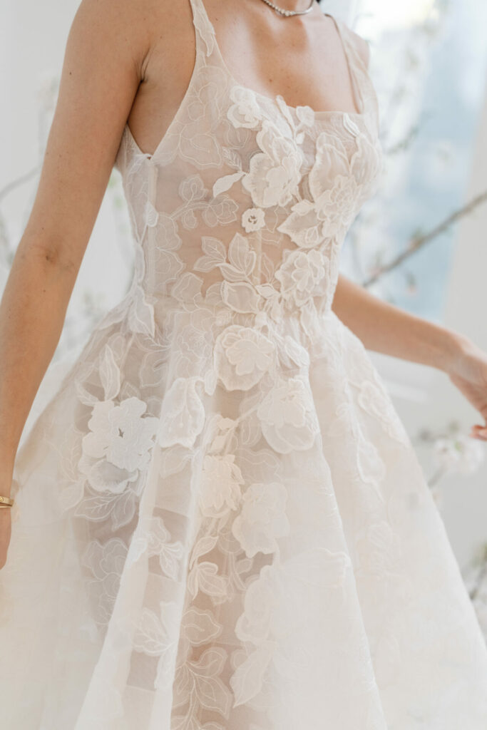 Woman in white floral lace sleeveless dress.