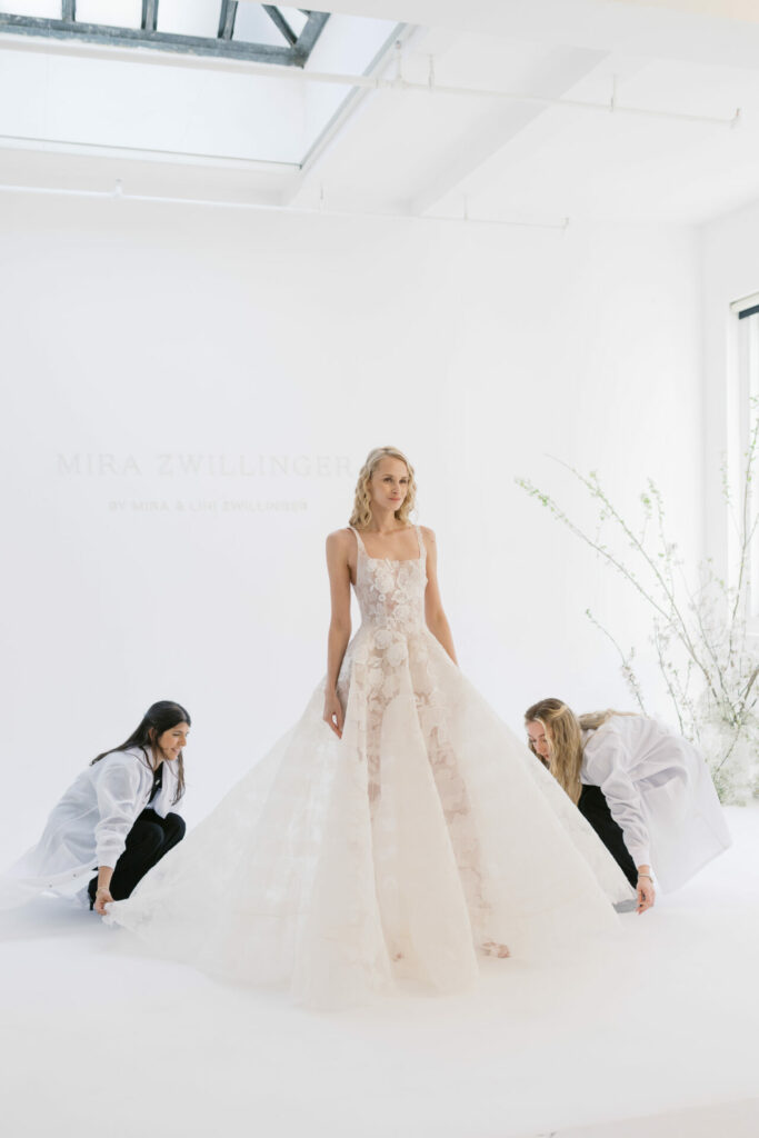 Bride in lace dress with train adjusted.
