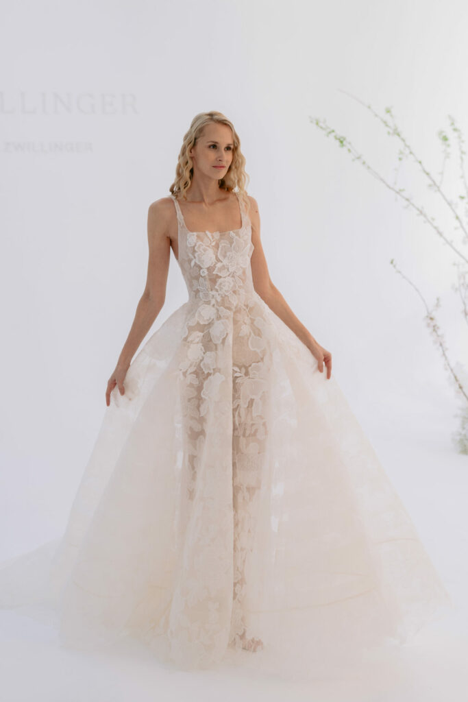 Bride in sheer lace dress with branches.