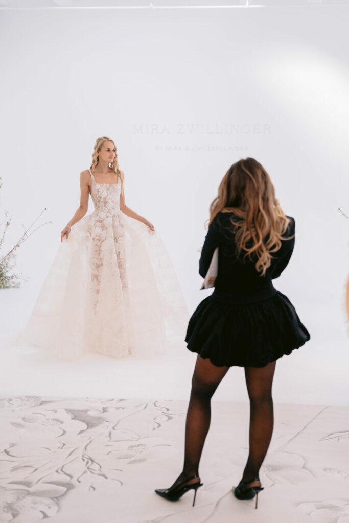 Model in floral wedding gown poses for photo.
