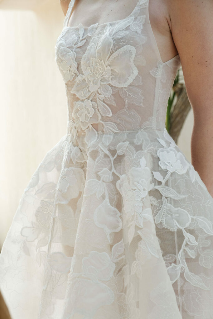 Close-up of sheer floral lace wedding dress.